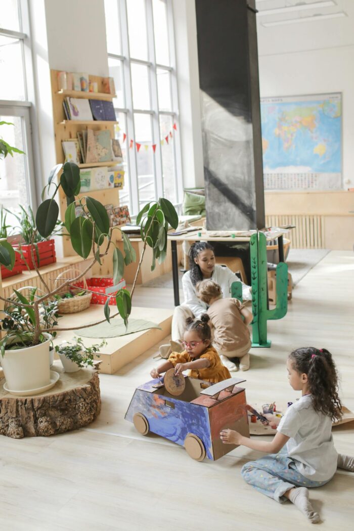 Children engaged in creative play in a well-lit classroom with educational materials.